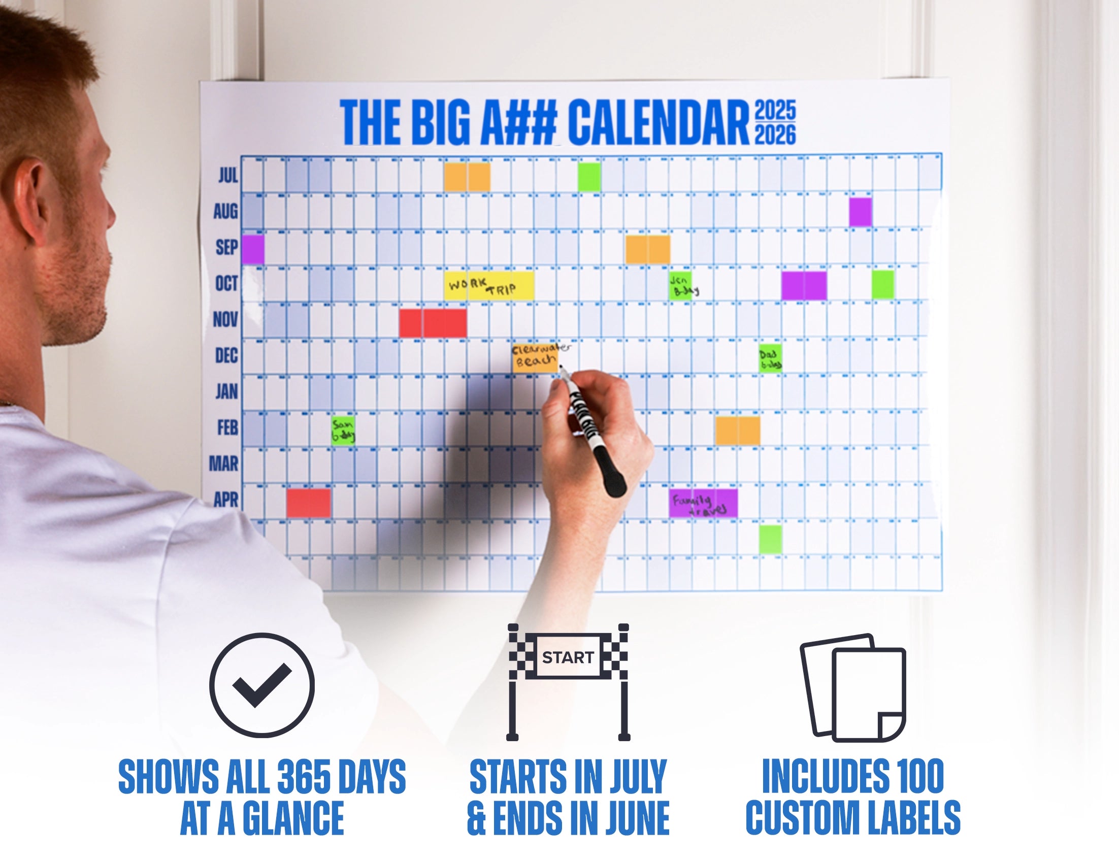 Person using a colorful calendar with text overlay on a white wall.